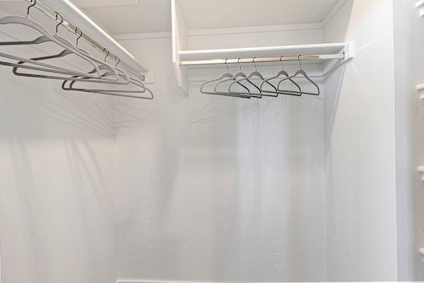 A white closet with clothes hangers. at AVIA Lofts on Victors Way, Boise, ID 83709